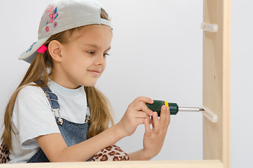 Image showing Child screwed fastening wooden cabinet