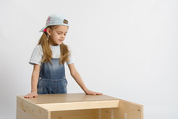 Image showing child looks at the result of assembling furniture