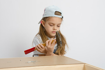 Image showing Girl holding a hammer wrong