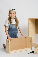 Image showing Girl collects furniture