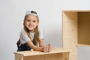 Image showing Girl sitting with an assembled frame and chest wooden box