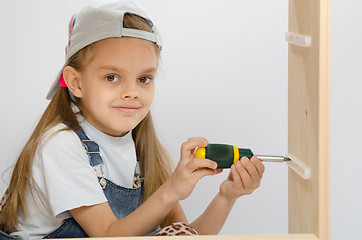 Image showing Child spins mounting boxes, collecting cabinet