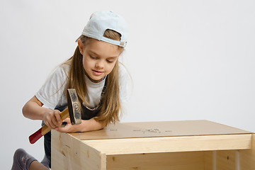 Image showing Girl in classroom work to hammer nail with a hammer