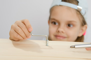 Image showing Girl in the classroom working spins screw