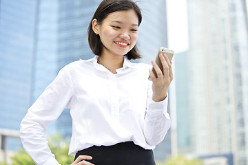 Image showing Asian young female executive looking at smart phone