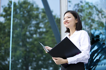 Image showing Asian young female executive holding file smiling