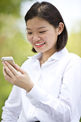 Image showing Asian young female executive looking at smart phone