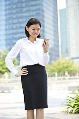 Image showing Asian young female executive looking at smart phone