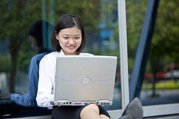 Image showing Asian young female executive using laptop