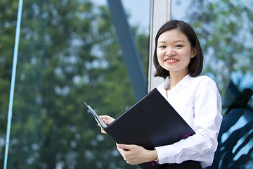 Image showing Asian young female executive holding file smiling