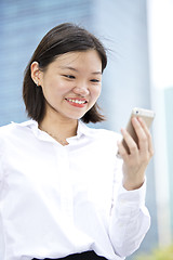 Image showing Asian young female executive looking at smart phone