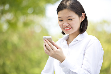 Image showing Asian young female executive looking at smart phone