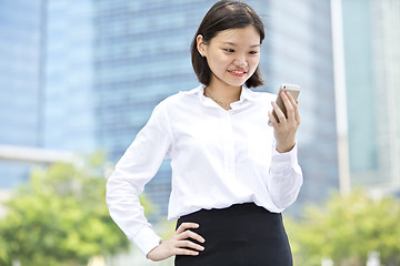 Image showing Asian young female executive looking at smart phone