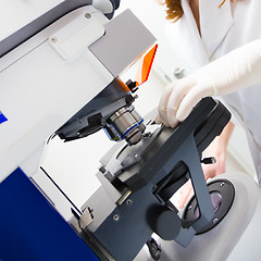 Image showing Scientist microscoping on fluorescent microscope. 