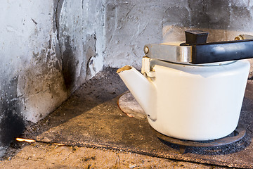 Image showing Old iron kettle on village oven 