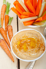 Image showing fresh hummus dip with raw carrot and celery 