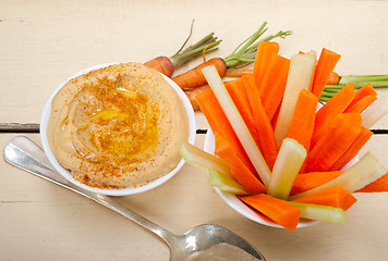 Image showing fresh hummus dip with raw carrot and celery 