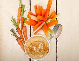 Image showing fresh hummus dip with raw carrot and celery 