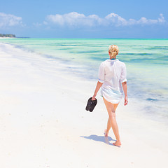 Image showing Woman running on the beach in sunset.