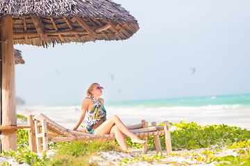 Image showing Woman sunbathing on tropical beach.