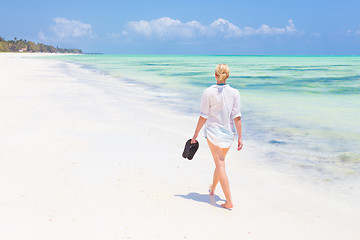 Image showing Woman running on the beach in sunset.