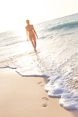 Image showing Woman running on the beach in sunset.