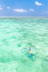 Image showing woman snorkeling in turquoise blue sea.