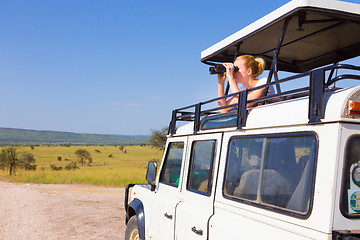 Image showing Woman on safari looking through binoculars.