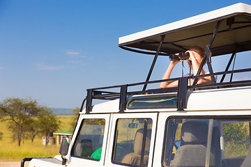 Image showing Woman on safari looking through binoculars.