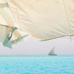 Image showing Traditional wooden sailboat sailing on horizon.