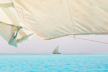 Image showing Traditional wooden sailboat sailing on horizon.