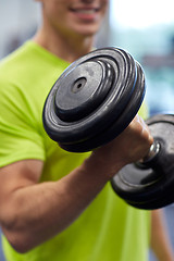 Image showing close up of smiling man with dumbbell in gym