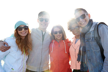 Image showing happy teenage friends in shades hugging on street