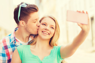 Image showing smiling couple with smartphone in city
