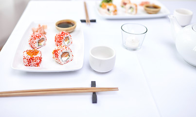 Image showing close up of woman eating sushi at restaurant