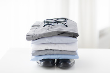 Image showing close up of folded male shirts and shoes on table
