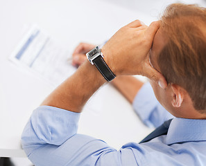 Image showing stressed man filling tax form