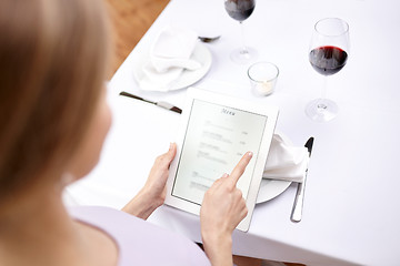 Image showing close up of woman with tablet pc at restaurant