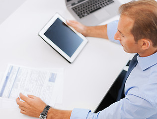 Image showing businessman with tablet pc and papers in office