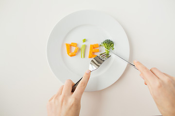 Image showing close up of woman hands eating vegetables