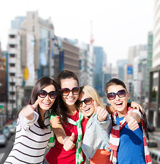 Image showing happy teenage girls showing thumbs up at city