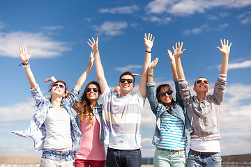 Image showing group of smiling teenagers holding hands up