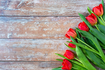 Image showing close up of red tulips on wooden background