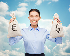 Image showing businesswoman holding money bags with euro