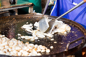 Image showing close up of cook frying meat at street market