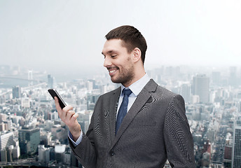 Image showing young smiling businessman with smartphone