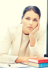 Image showing bored and tired woman behid the table