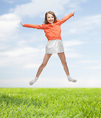 Image showing happy girl in casual clothes jumping high