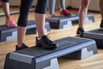 Image showing close up of women exercising with steppers in gym