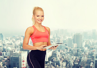 Image showing smiling sporty woman with tablet pc computer